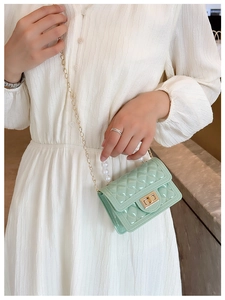 Detail of mint green jelly handbag with pearl handle and quilted pattern for girls