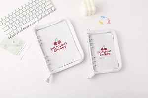 Detail view of A5 and A6 clear PVC binders with white zippers and cherry pattern inserts