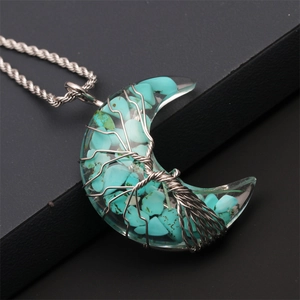 Detailed wire-wrapped silver tree of life inside a turquoise stone moon pendant necklace