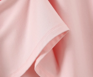 Vue détaillée du tissu en maille rose avec finitions soignées en couture à double aiguille