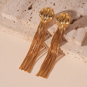 Macro detail of gold geometric stud earrings with elegant cascading snake chain tassels