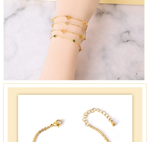 Detail of gold bracelet with heart and star charms featuring a lobster clasp and chain
