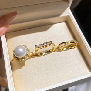 Close-up of pearl and zircon flower rings set on a velvet jewelry box display