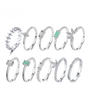 Set of S925 sterling silver rings with emerald and clear crystal stones on white background