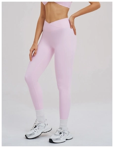 Détail du legging de yoga rose montrant la taille haute croisée en V et la texture douce