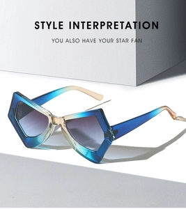 Macro shot of stylish geometric cat-eye sunglasses with blue and pink gradient resin frame