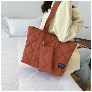 Detail of quilted brick red nylon shoulder bag with matching square coin purse accessory