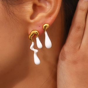 Detail shot of Y2K style asymmetrical melting lava stud earrings in gold and white finish