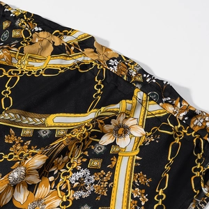 Gros plan détaillé de l'imprimé chaîne baroque dorée sur tissu noir effet soie brillante