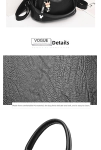 Close-up of black litchi grain PU leather backpack with a cute cartoon cow keychain accessory