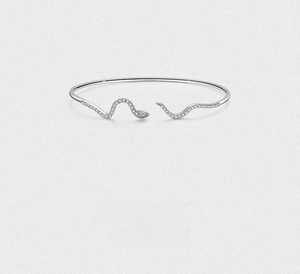 Dettagli del bracciale a serpente in argento con pietre lucide e occhi verdi