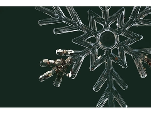 Macro detail of transparent acrylic snowflake pendant with silver glitter for Christmas tree