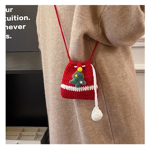 Detail of red crochet reindeer bag with Christmas tree decor on a knit sweater
