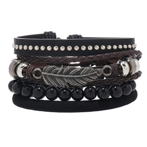 Close-up of multilayer men's leather bracelet set featuring a silver feather charm and beads