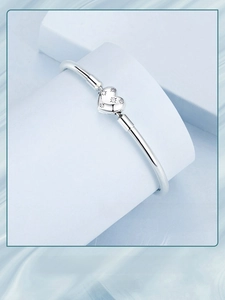 Macro detail of S925 sterling silver star heart bracelet on light blue geometric prop
