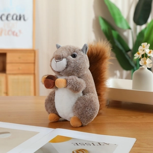 Realistic squirrel plush toy with acorn on wooden desk in a cozy home setting