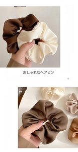 Detailed view of large satin scrunchies in brown, beige, and cream silk-like fabric