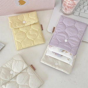 Close-up of pastel quilted storage pouches showing capacity for sanitary pad organization