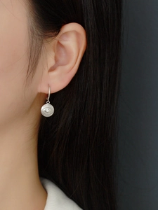 Detail of S925 sterling silver evil eye hoop earrings with engraved totem and shiny stone