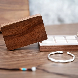 Detail of black walnut wood jewelry box featuring internal dividers and silver ring