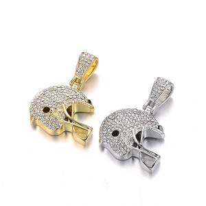 Gros plan de pendentifs casques de football américain en or et argent sertis de strass