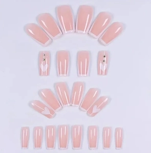 Détails de faux ongles French roses avec motifs de cœur blancs et strass scintillants