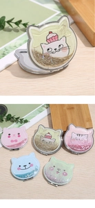 Close-up of portable cat-shaped folding mirrors with colorful flowing glitter and sand