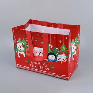 Red Christmas non-woven gift bag featuring Santa and penguin with Merry Christmas print