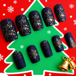 Christmas press-on nails in matte dark blue with gold snowflake and tree patterns
