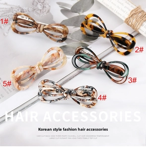 Detailed close-up of acetate bow hair clips in various tortoiseshell and marble patterns
