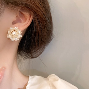 Close-up of floral pearl earrings on a model showing French style aesthetic detail