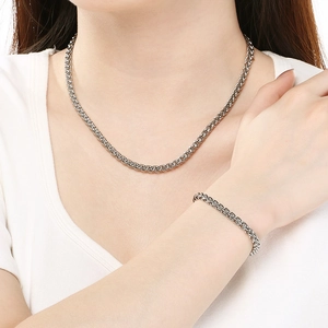 Gros plan d'un ensemble collier et bracelet en acier inoxydable tressé argenté