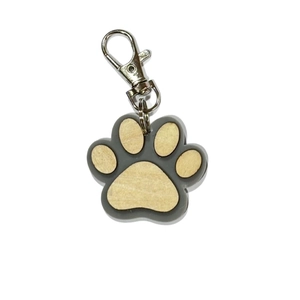 Detail of wooden pet paw print keychain featuring smooth timber texture and metal clasp