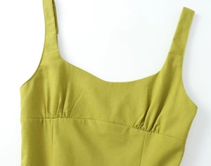 Detail of mustard green linen dress showing pleated neckline and strap craftsmanship