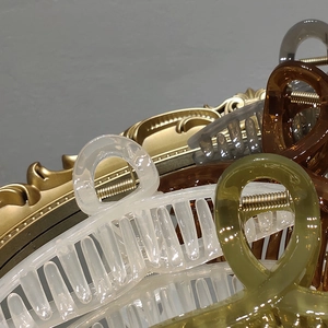 Detailed close-up of colorful jelly texture hair claws stacked on a vintage mirror
