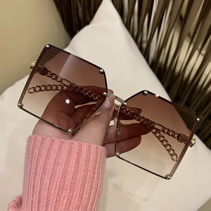 Women's oversized square sunglasses with brown gradient lenses and gold chain temples