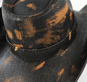 Dettaglio della trama in paglia intrecciata con vernice vintage sul cappello da cowboy