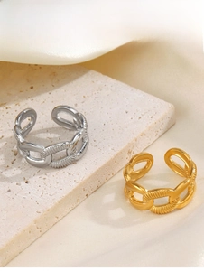 Detail of 18K gold and silver chain link rings with hammer texture on stone background