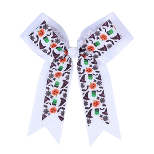 Detail of white Halloween bow clip with pumpkin, bat and witch hat grosgrain patterns