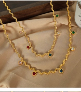 Close-up of golden twist chain necklace with colorful heart-shaped zircon stones