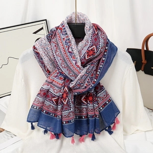 Detail view of geometric bohemian scarf with blue and red patterns and fringe tassels