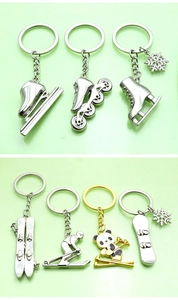 Detailed view of silver metal winter sports keychains featuring skis and ice skates
