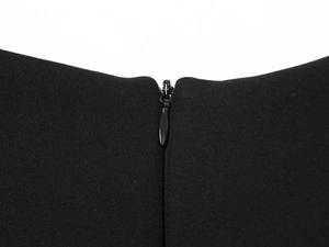 Detail of hidden zipper closure on black woven jumpsuit with sharp fabric texture