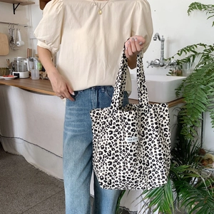 Detail of leopard print canvas tote bag with woven label in a kitchen lifestyle setting