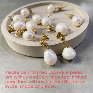 Detail view of natural baroque pearl earrings on a tray with 14K gold plated stainless steel