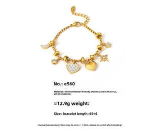 Detail of gold stainless steel bracelet with zircon moon, star, and heart charms