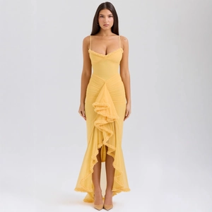 Detail of yellow dress with fine straps, layered mesh ruffles and asymmetric fishtail hem
