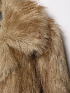 Macro detail of soft brown faux fur texture on a stylish women's fashion coat