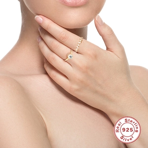 Close-up of 925 sterling silver gold rings with sparkling diamonds on a model's hand