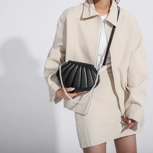 Elegante bolso bandolera negro con forma de concha, asa de perlas y correa de cuero